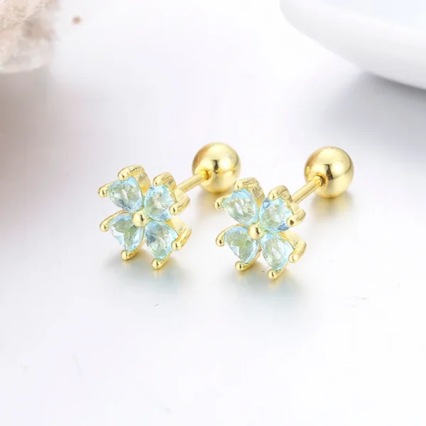 Boucles d&rsquo;oreilles trèfle dorées aux cristaux bleus