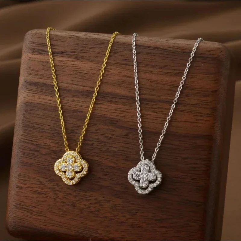 Deux colliers pendentifs trèfle à quatre feuilles, l'un en or jaune, l'autre en argent, sertis de cristaux brillants.