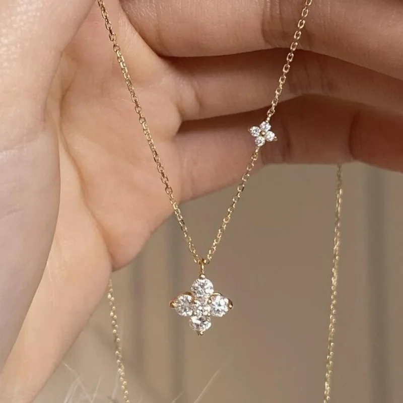 Collier en or jaune avec pendentif trèfle à quatre feuilles et zircons brillants.