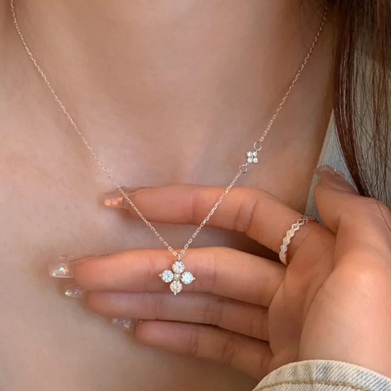 Collier délicat en or avec pendentif trèfle à quatre feuilles orné de zircons scintillants.